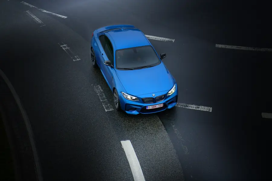 Blaues Auto auf einer Straße von oben